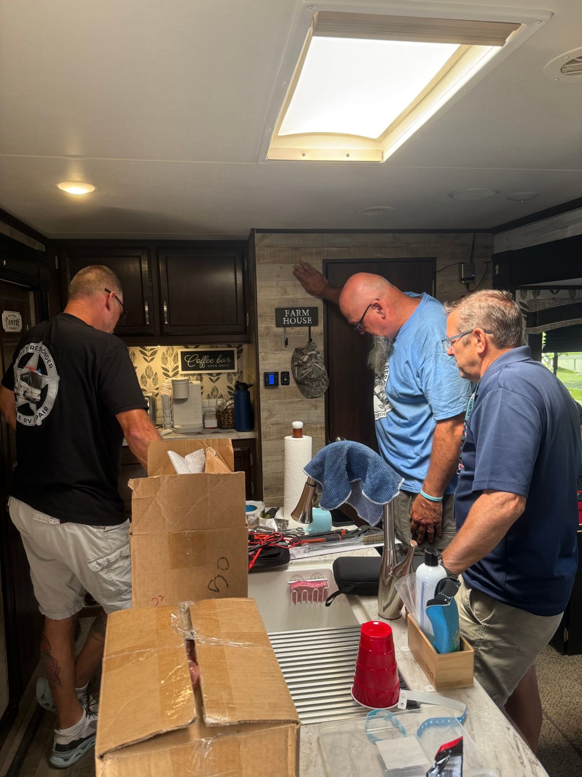 Three technicians working through a problem inside an RV