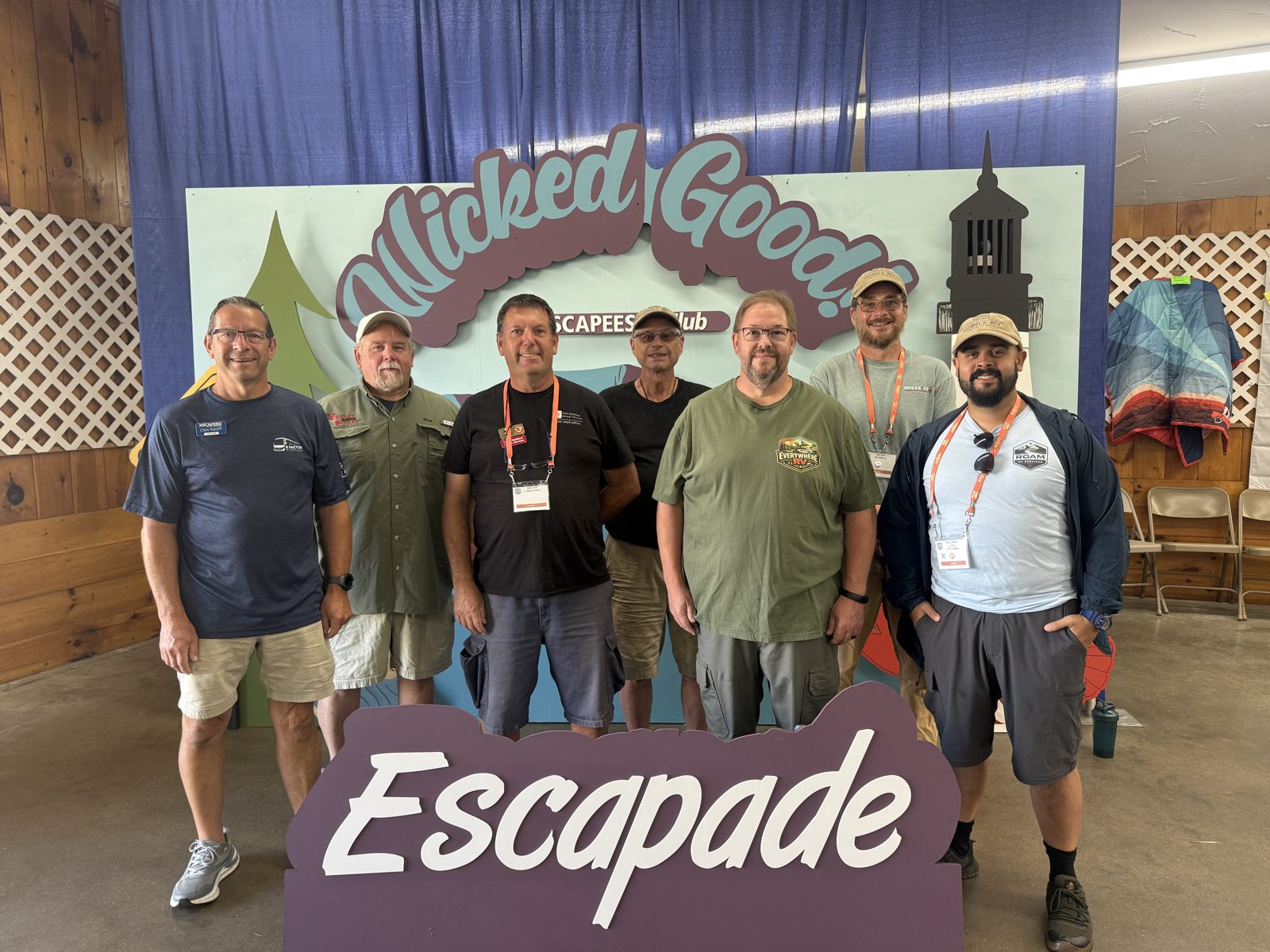 The Mobile RV Tech Crew at Escapade 2026, standing behind the Escapade sign
