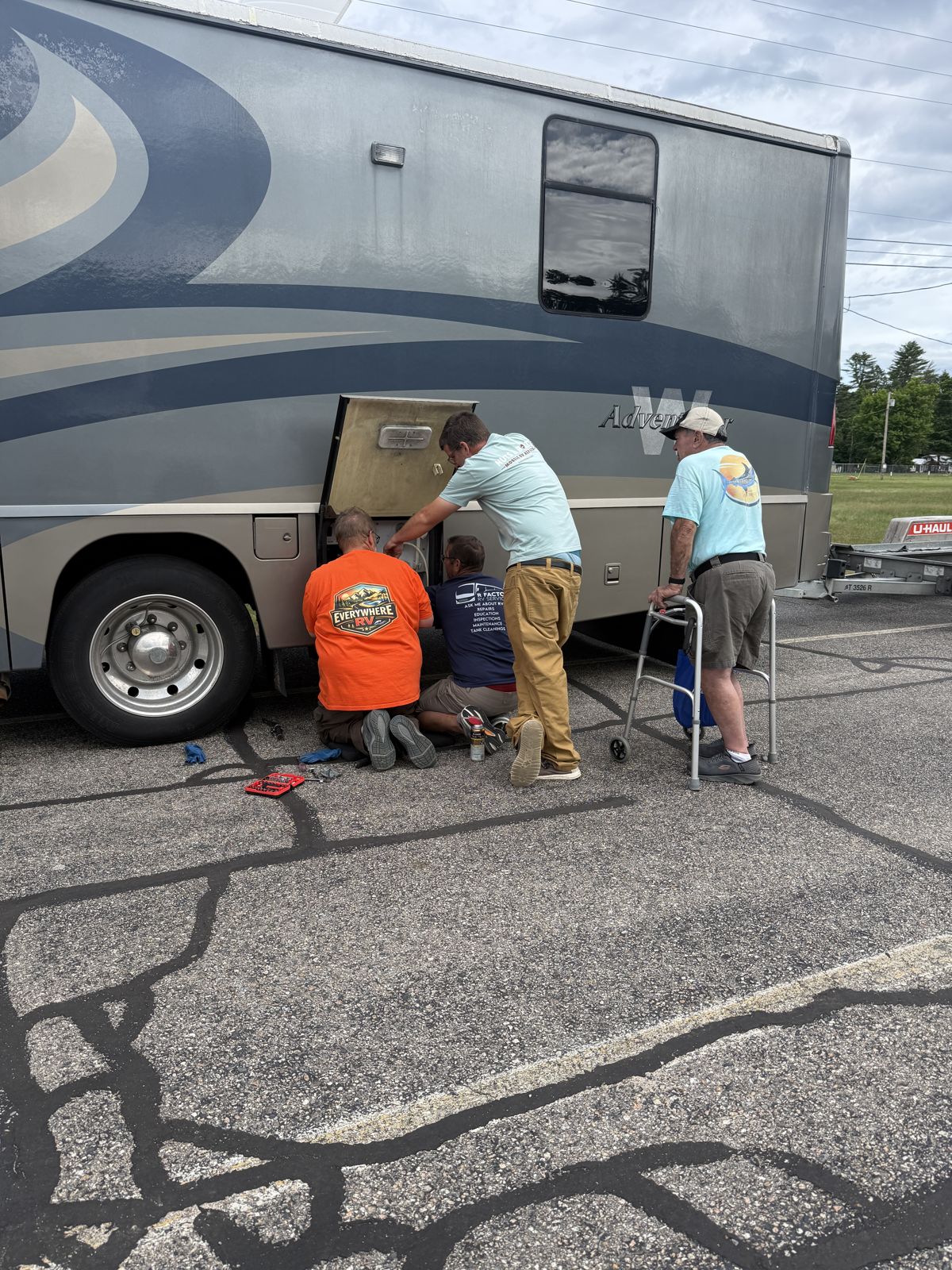 Technicians working in a motorhome basement compartment at Escapade